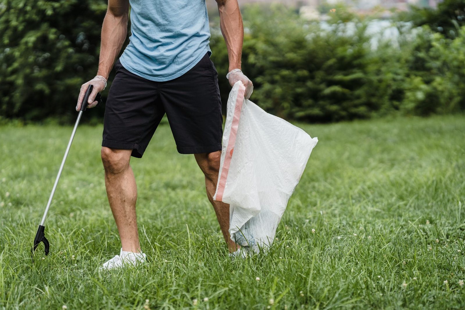 Man collecting garden waste into a bag