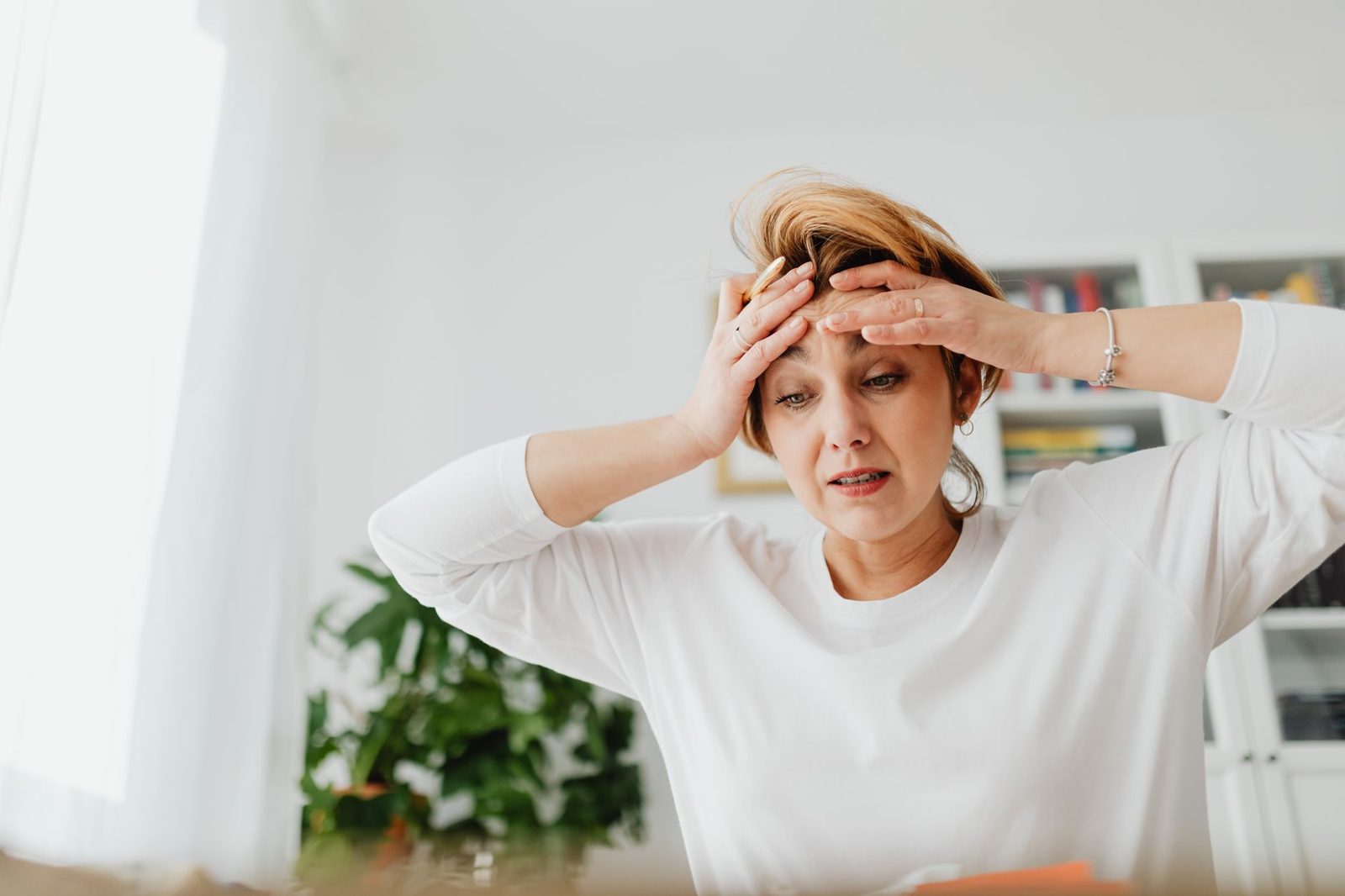 Woman with her hand on her forehead, overwhelmed
